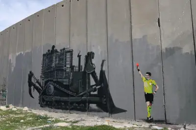 Grafiti en Belén muestra árbitro de UEFA expulsando excavadora israelí que amenaza campo de fútbol
